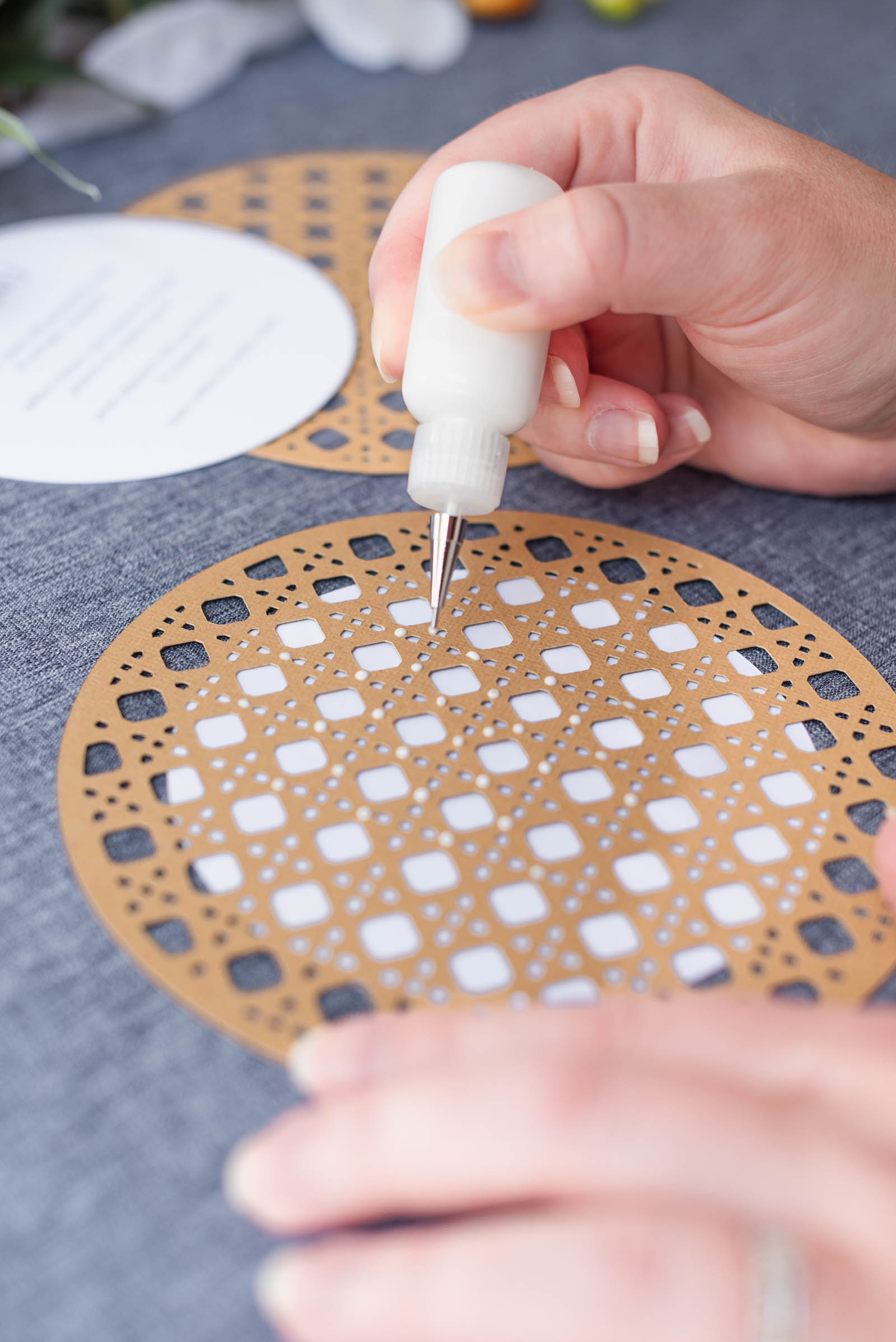 Applying Bearly Arts quick dry craft glue in a precision tip bottle to rattan wedding menus