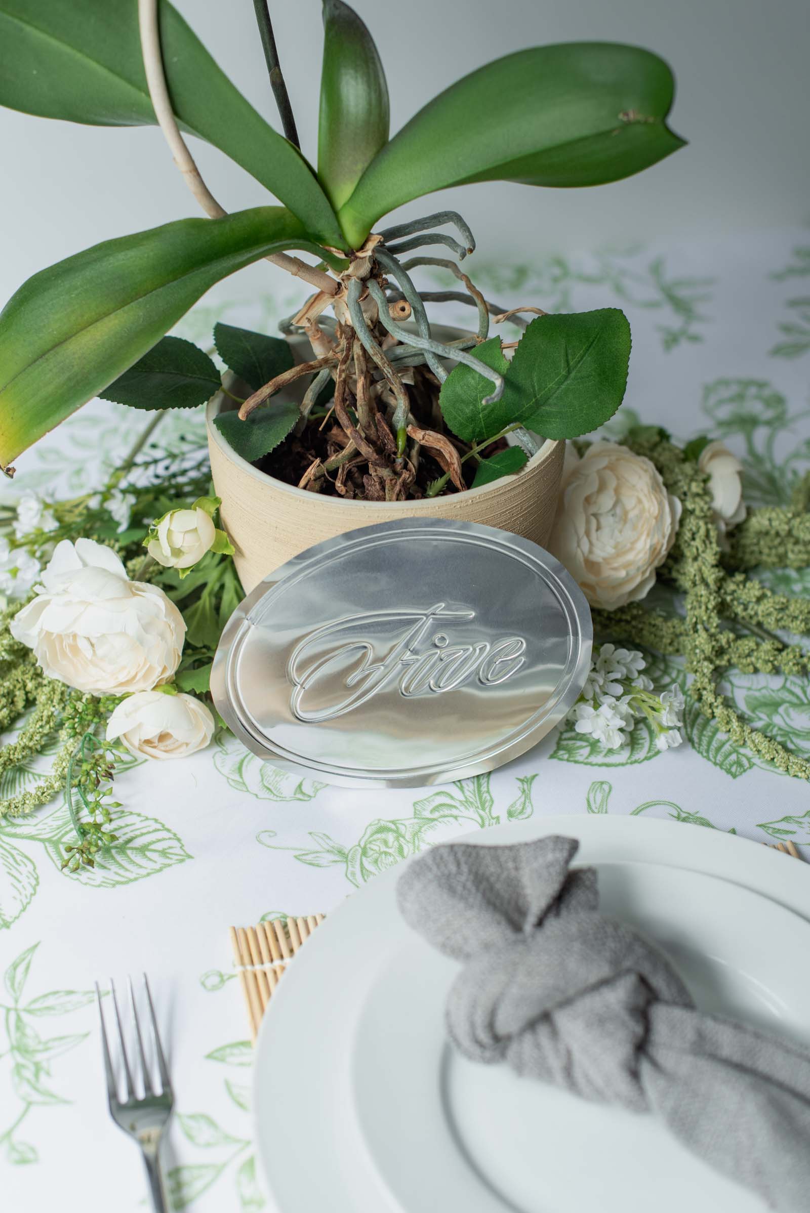 Silver metal foil sheets debossed into elegant wedding table numbers with a Cricut Maker machine