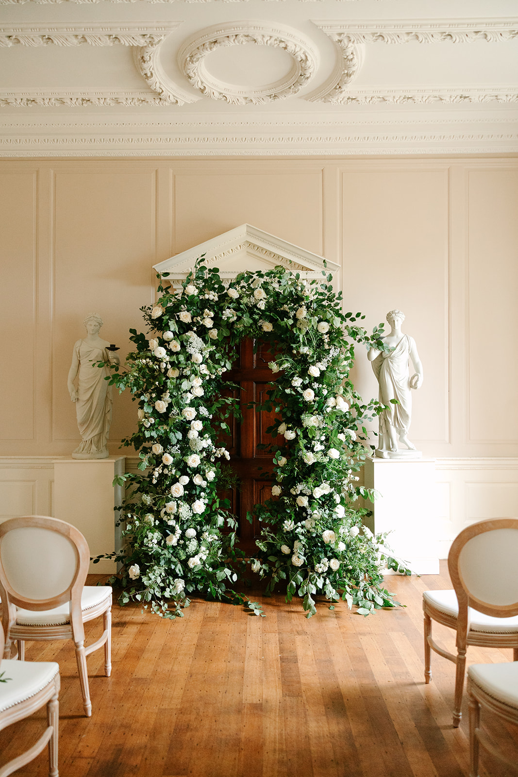 Lush English garden inspired wedding ceremony arch for indoor ceremony at Findon Place