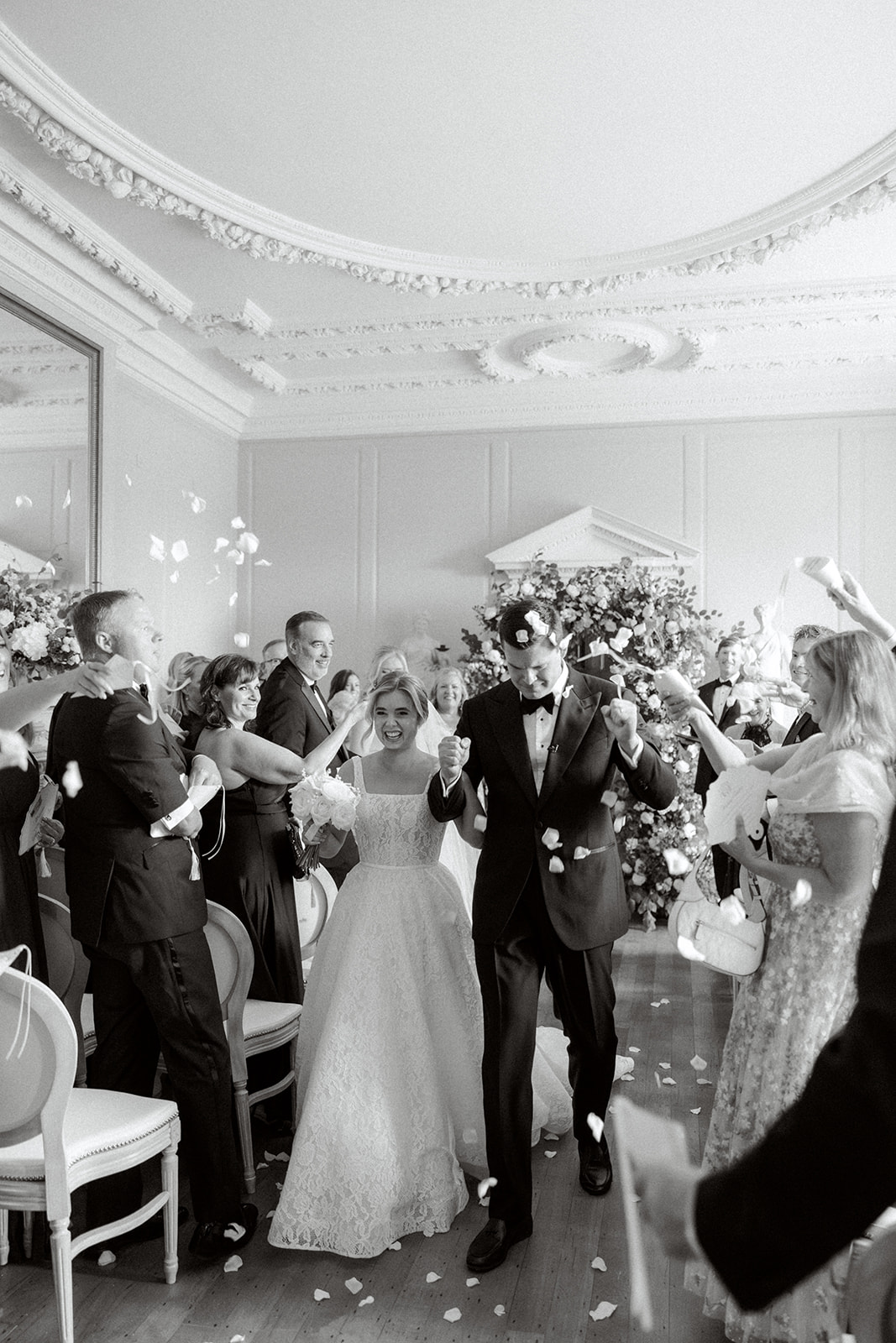 Bride and groom walking down aisle through rose petal confetti