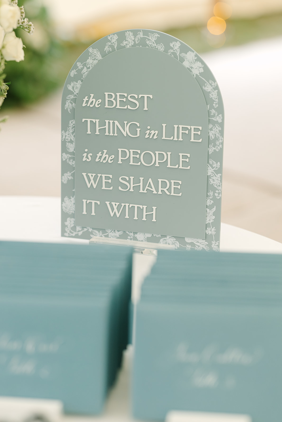 Arch shaped acrylic wedding sign that says The Best Thing in Life is the People We Share it with