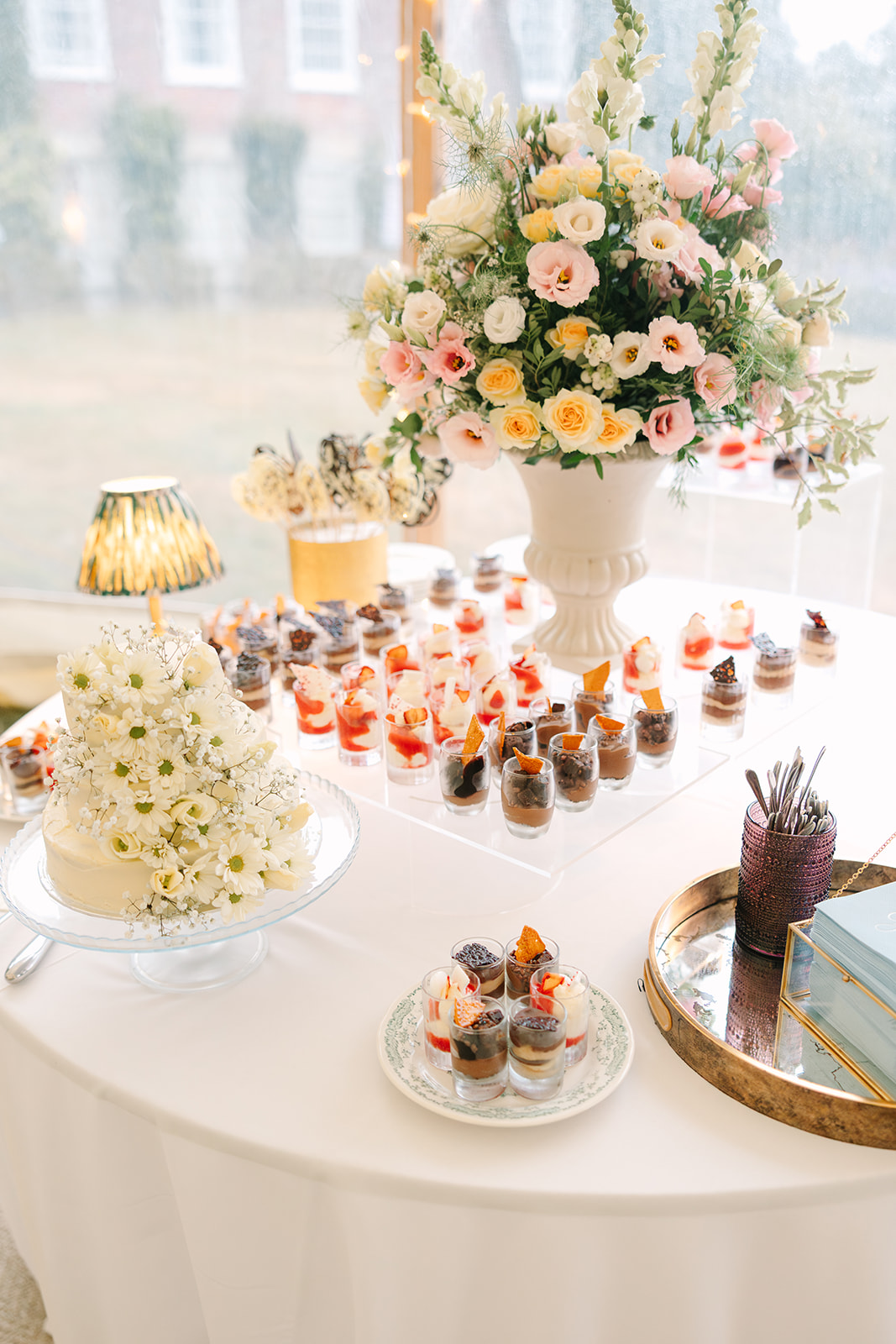 Modern dessert table with homemade DIY wedding cake decorated in daisies and babys breath