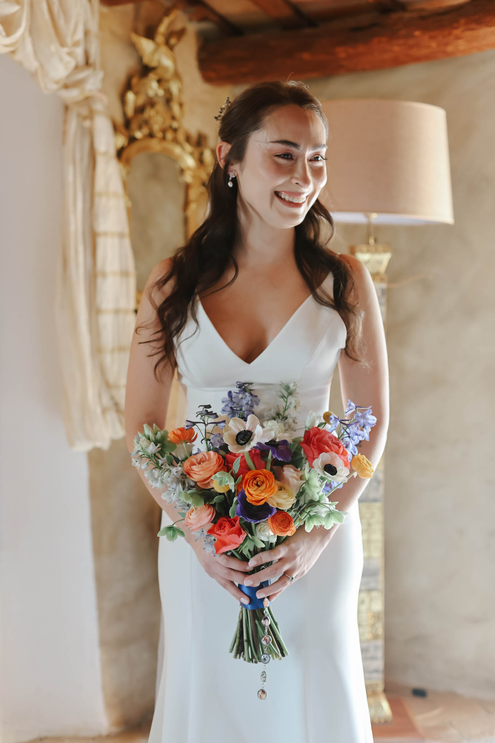 A bride wearing a white dress holding a colorful bouquet of flowers