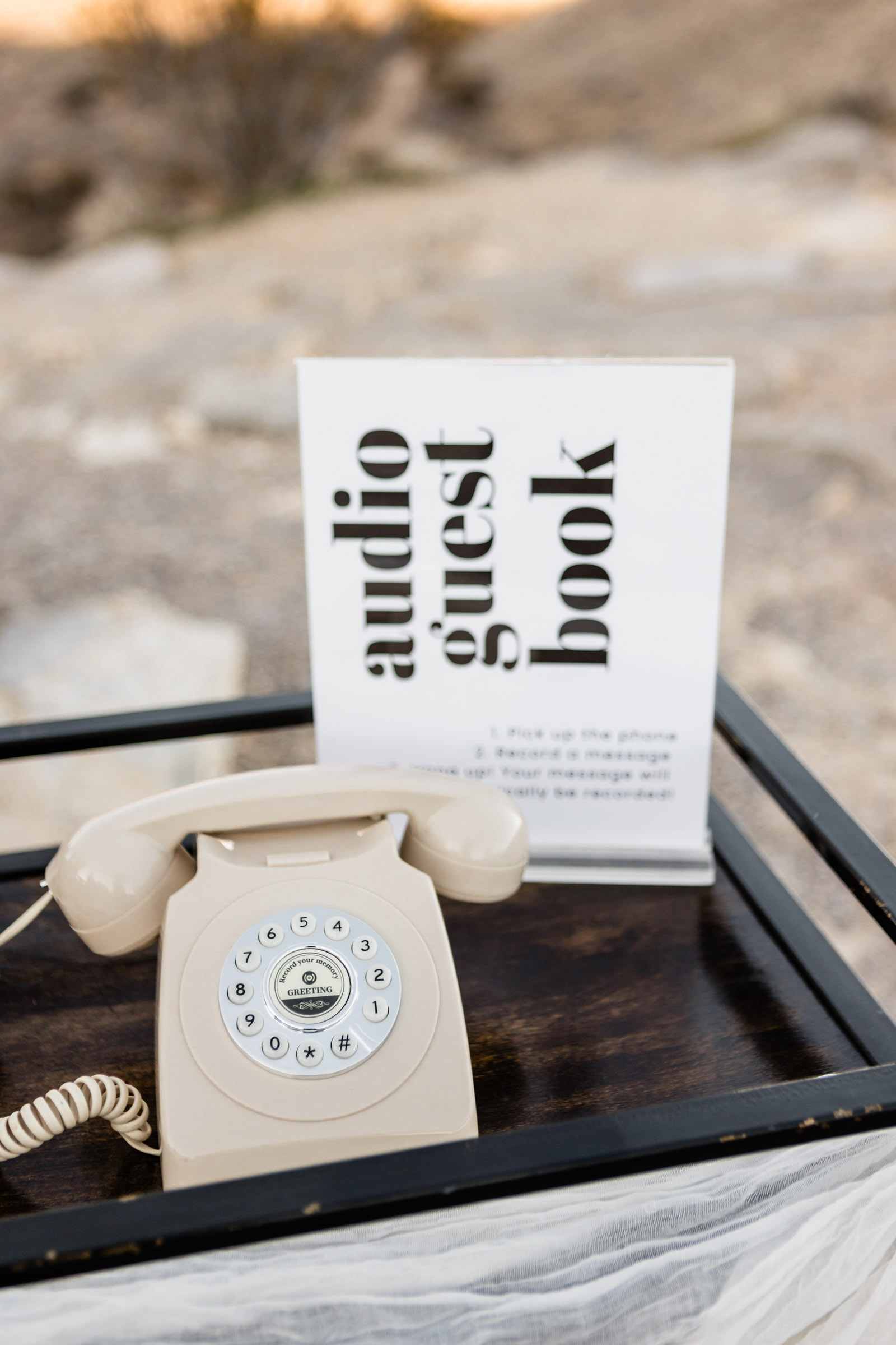 Modern white retro rotary phone with modern sign for a wedding audio guestbook setup