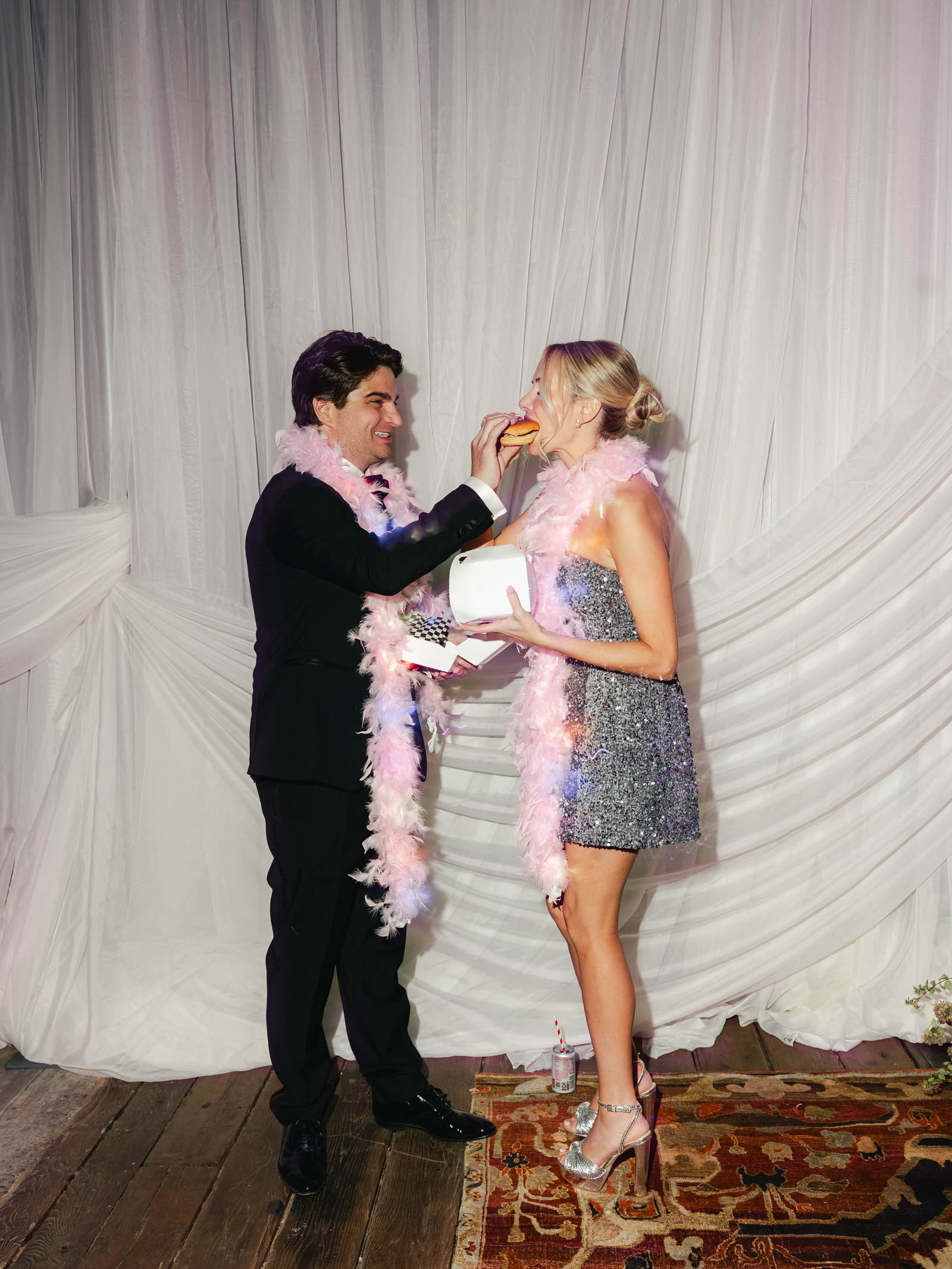 Bride and groom sharing a late night wedding snack of burgers and fries