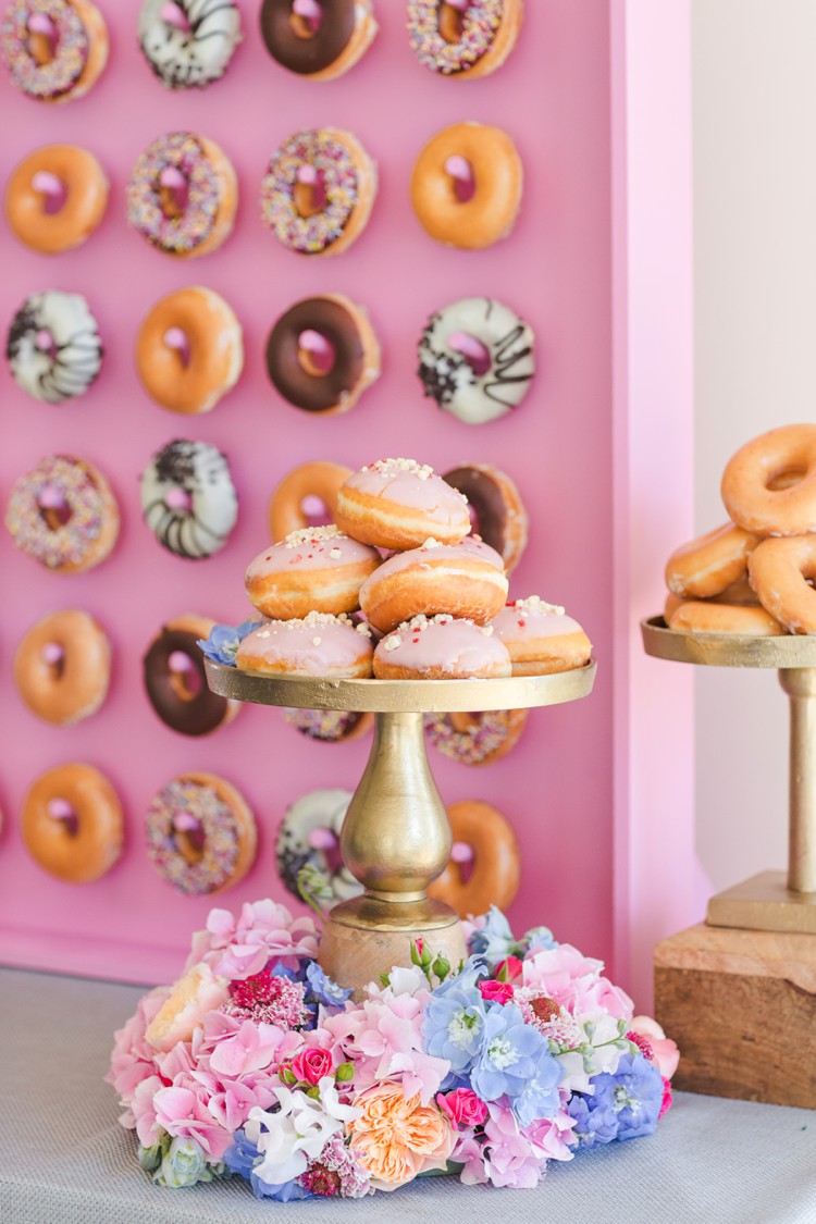 Pink colorful wedding doughnut display on gold stands