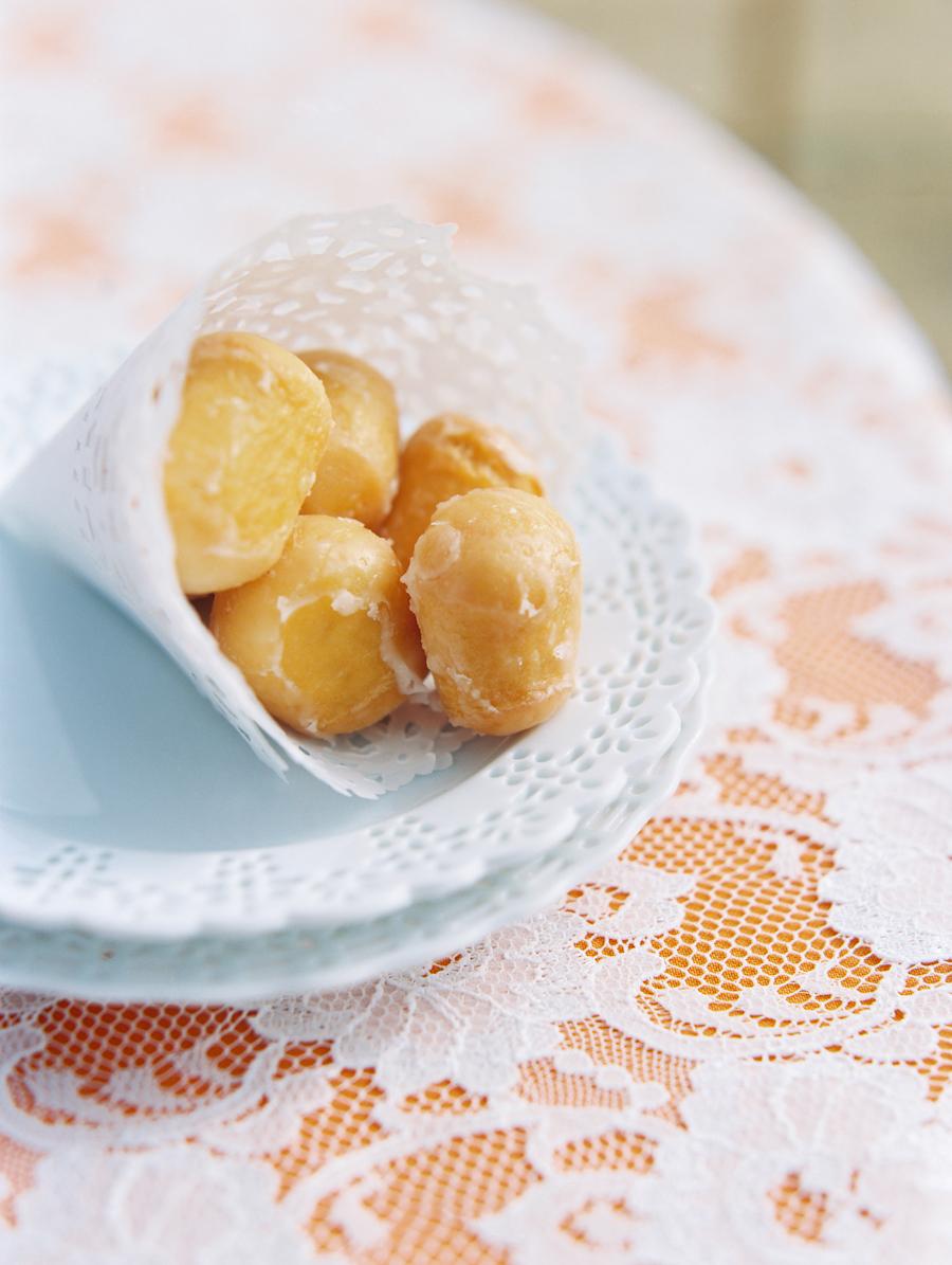 Glazed donut holes in a paper cone for a simple wedding snack