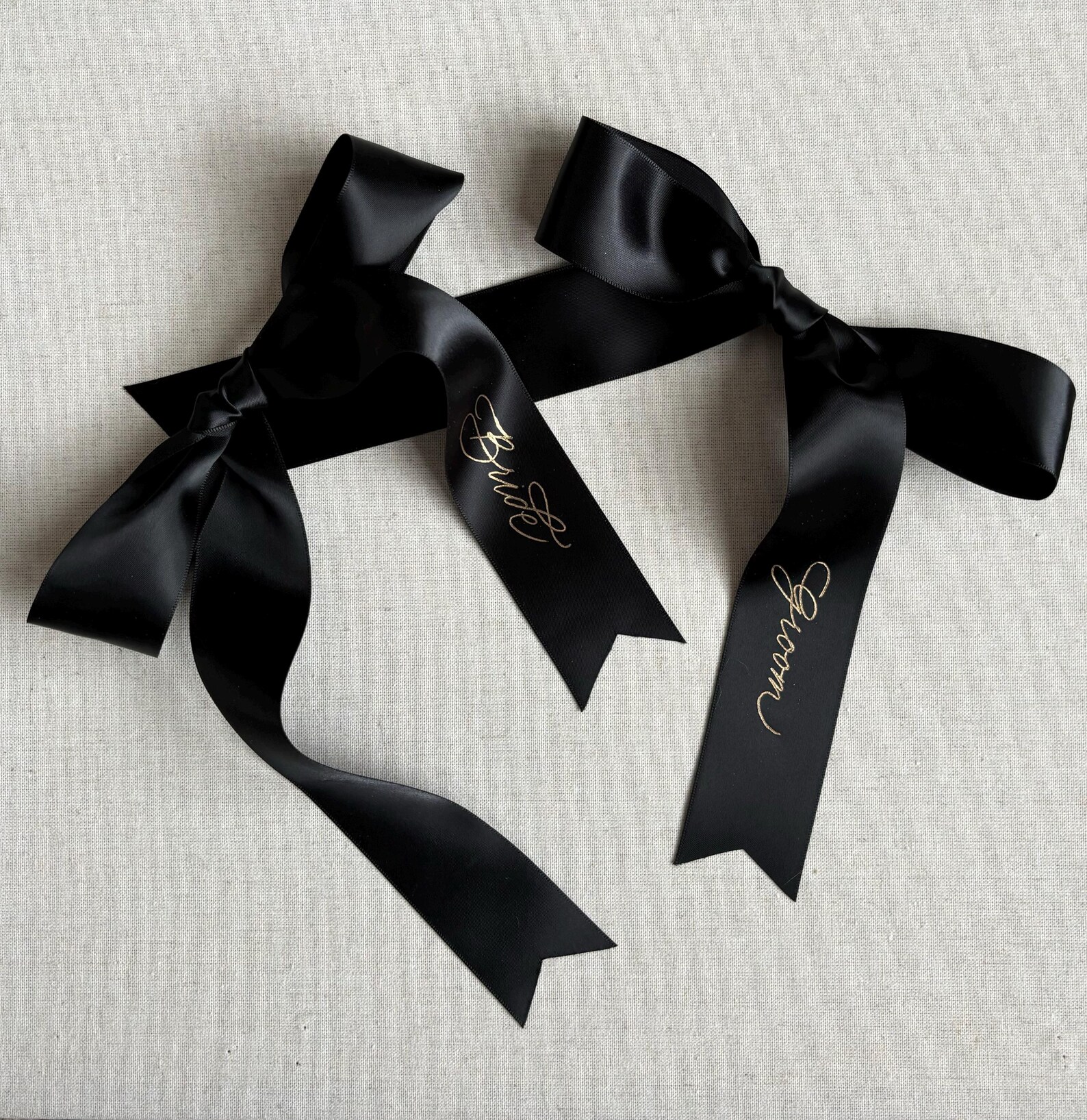 Bride and groom written in delicate hand gold calligraphy on black satin ribbons