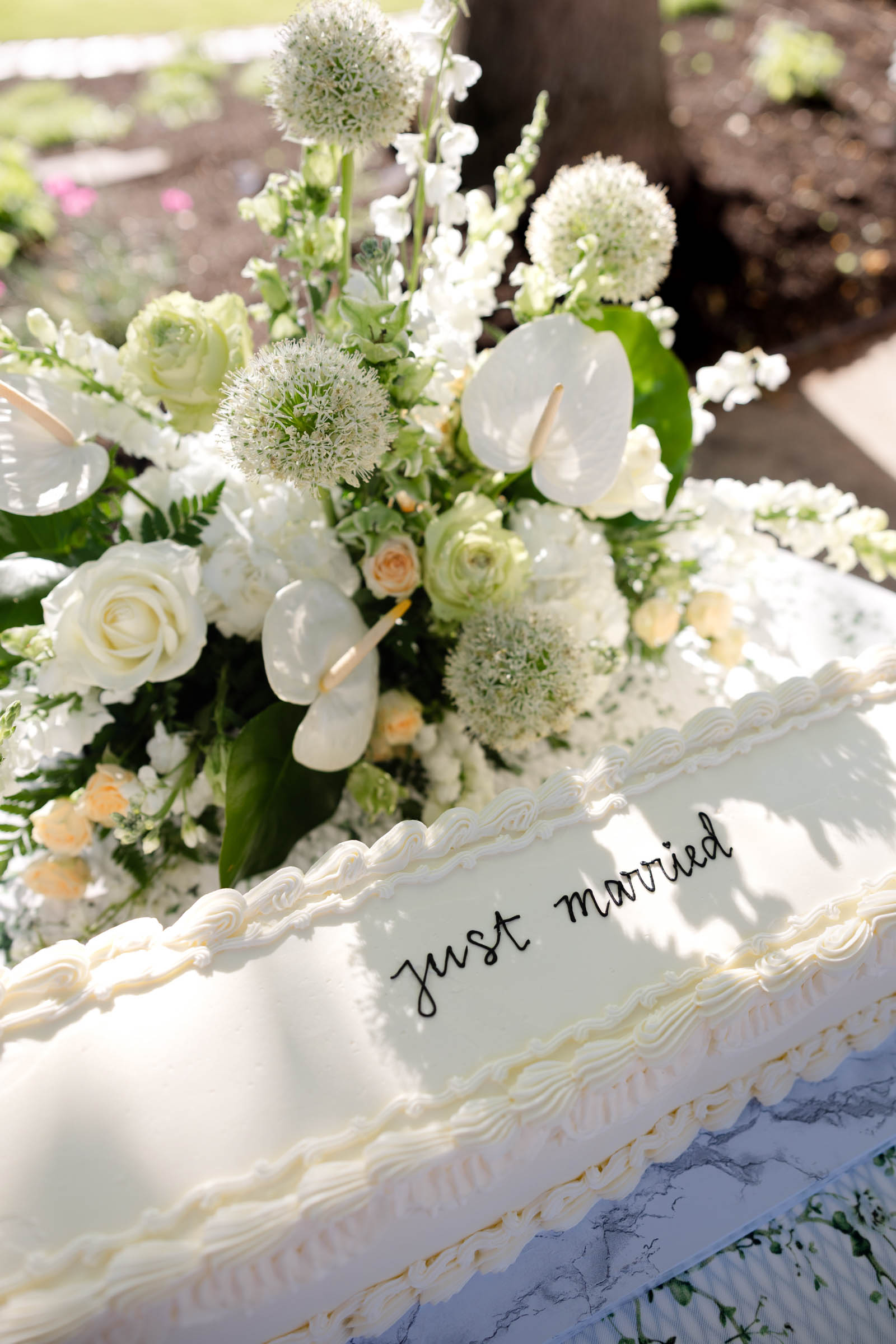 Classic modern long white wedding cake with Just Married written in black frosting