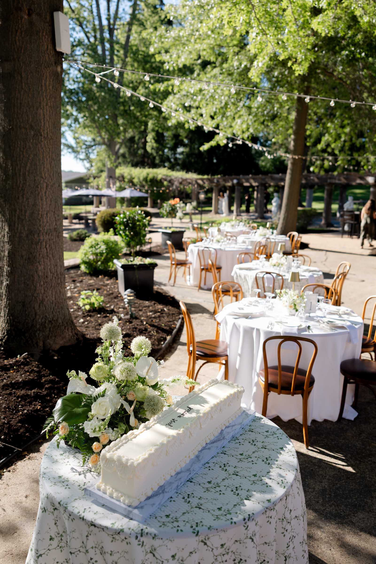 Classic modern long white wedding cake with Just Married written in black frosting for outdoor patio wedding