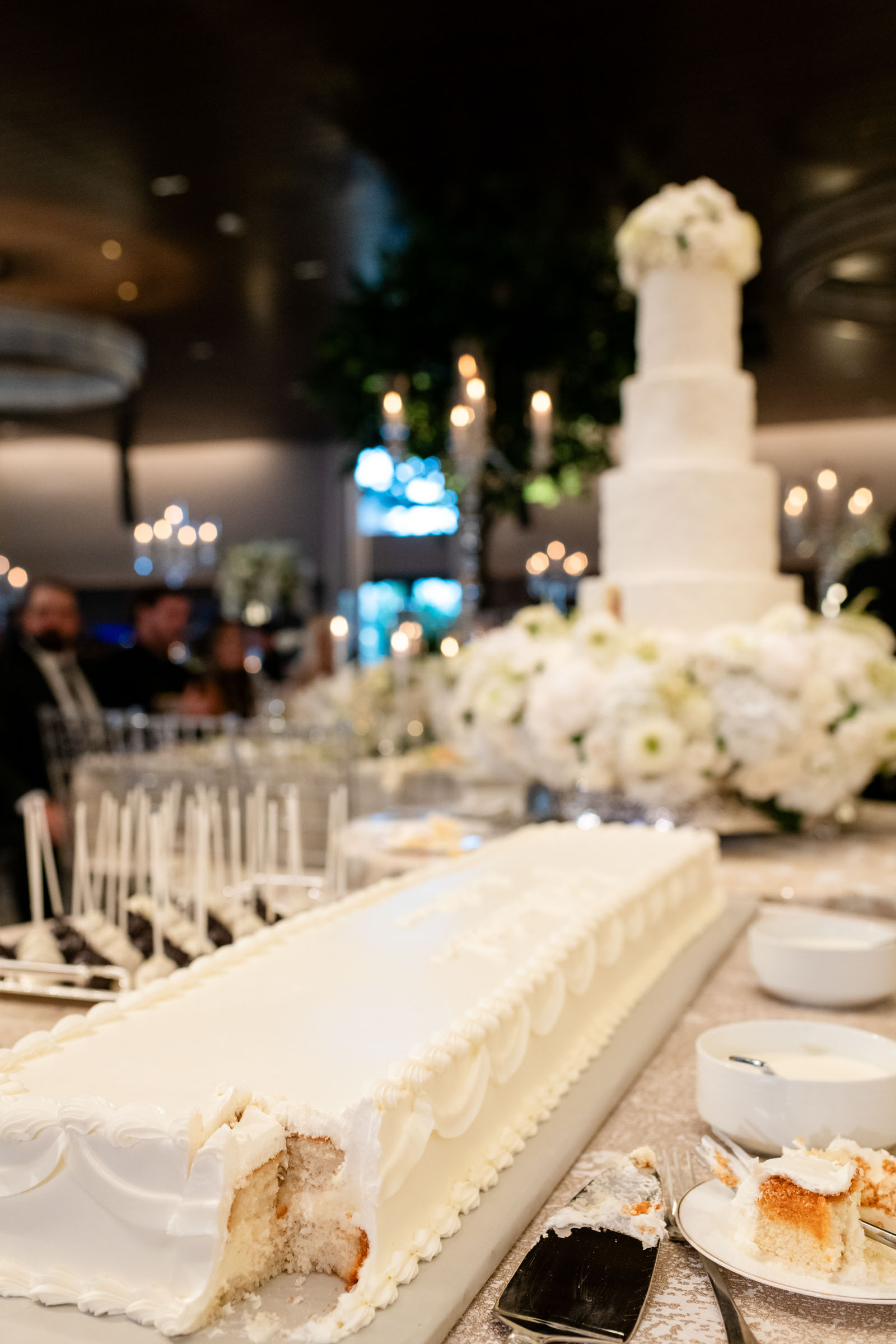 All-white long wedding cake with vintage lambeth piping details