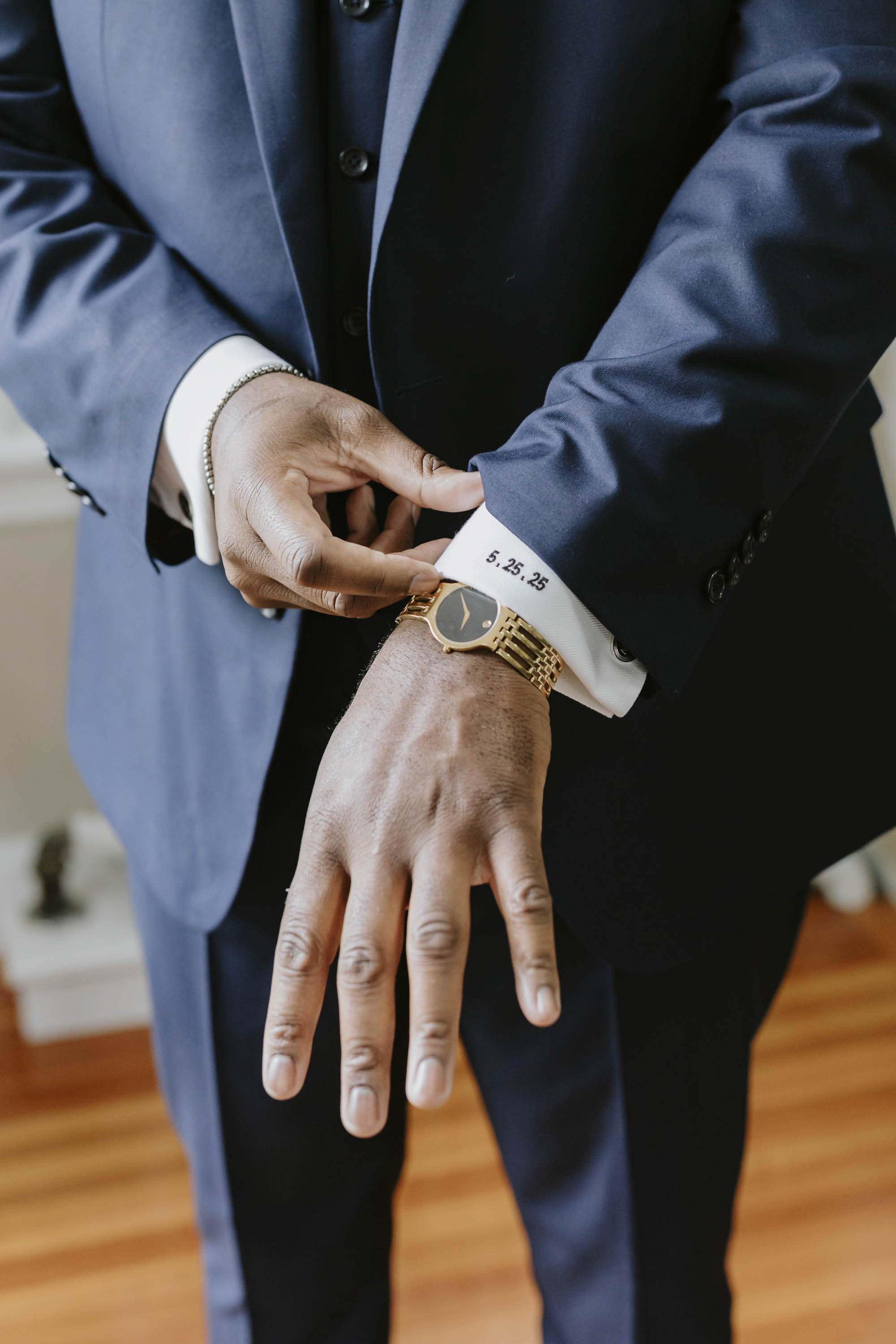 Groom with a custom embroidered wedding date on his shirt sleeve