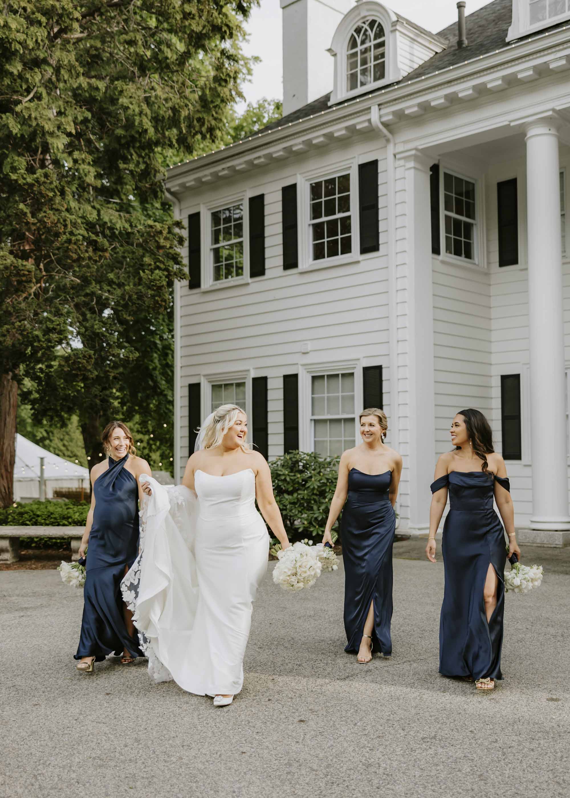 Bride and bridesmaid wearing pointed sweetheart neckline dresses in white and navy blue