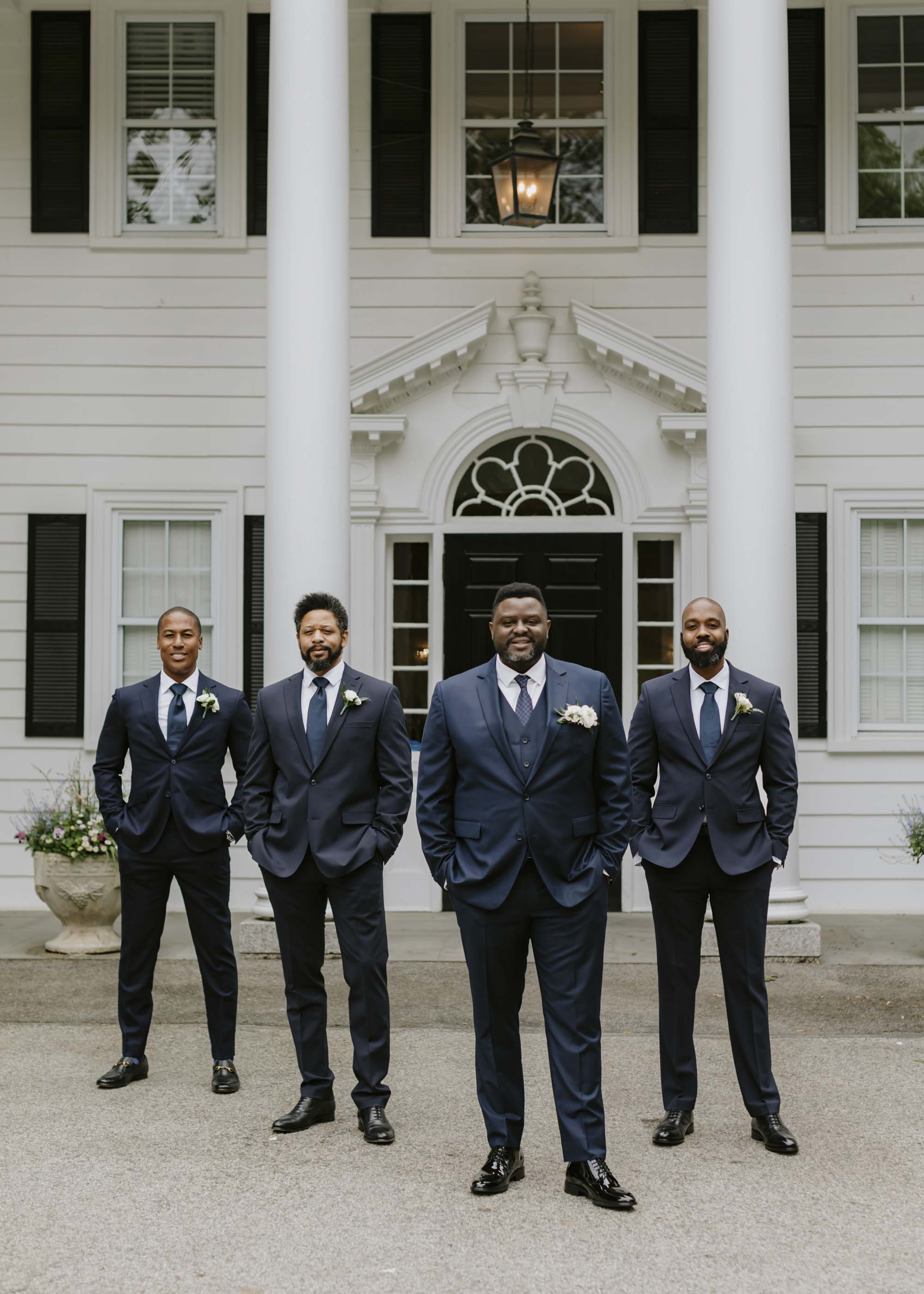 Groom and groomsmen wearing stylish navy blue suits for wedding day