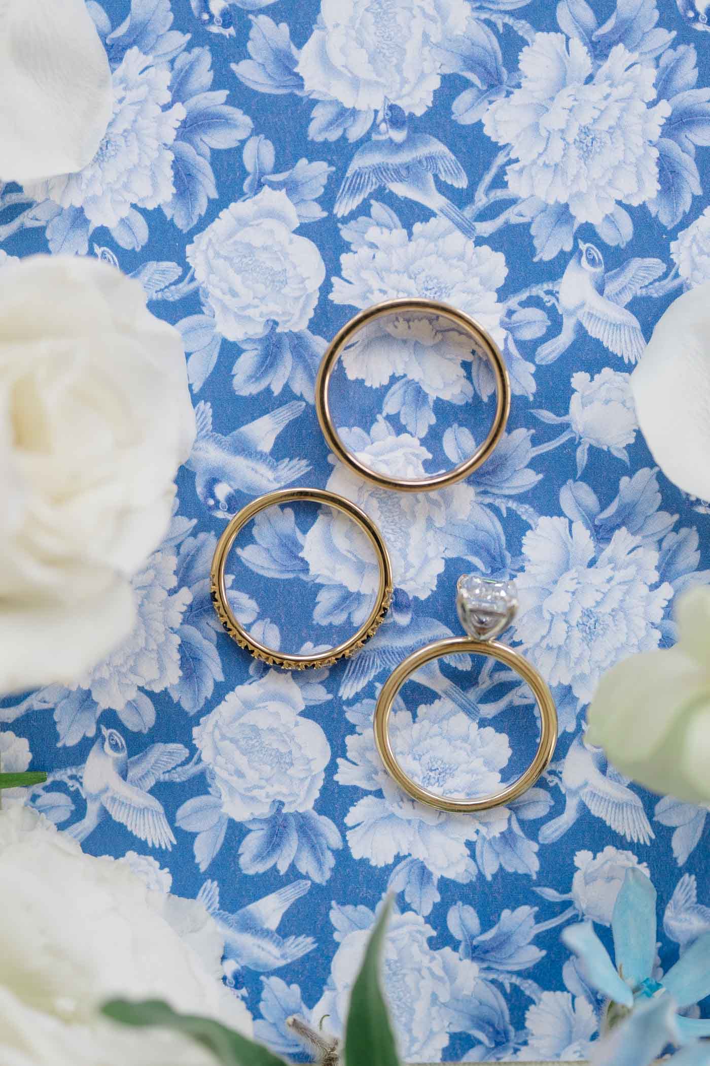 Gold wedding rings on blue and white Chinoiserie wedding invitation