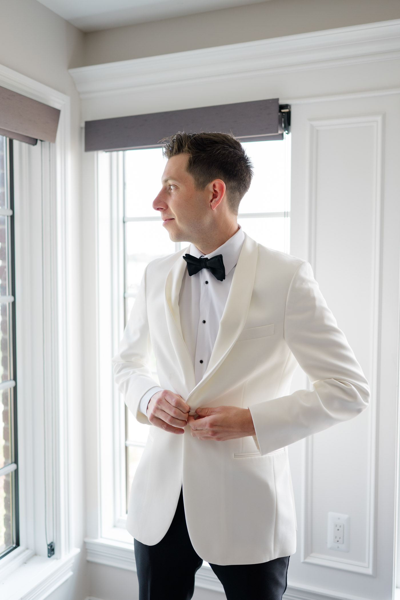 Groom wearing an all white tuxedo jacket