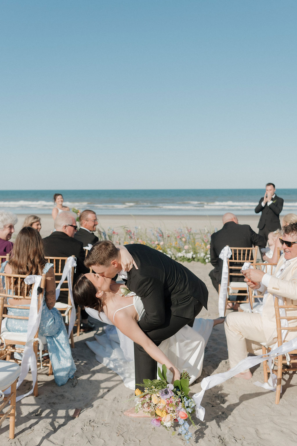 Bride and groom share a kiss after their wedding on the beach in the Outer Banks