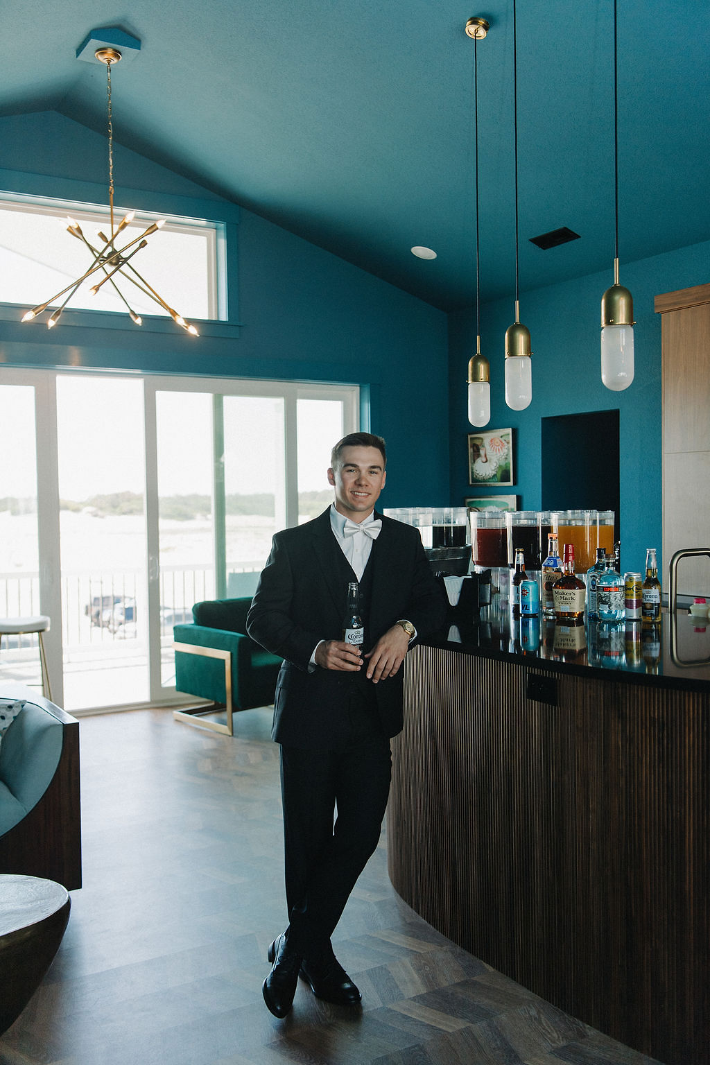 Groom drinking a Corona beer at his luxury beach house wedding in Outer Banks