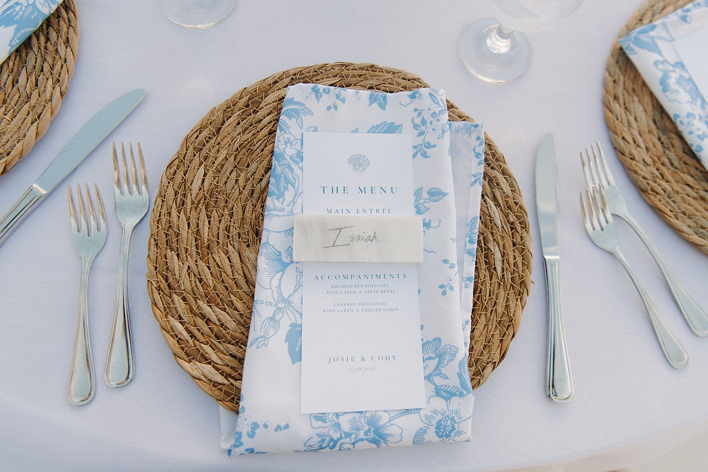 Beach blue floral napkins, menu with seashell illustration, and marble slab place card for elegant coastal place settings