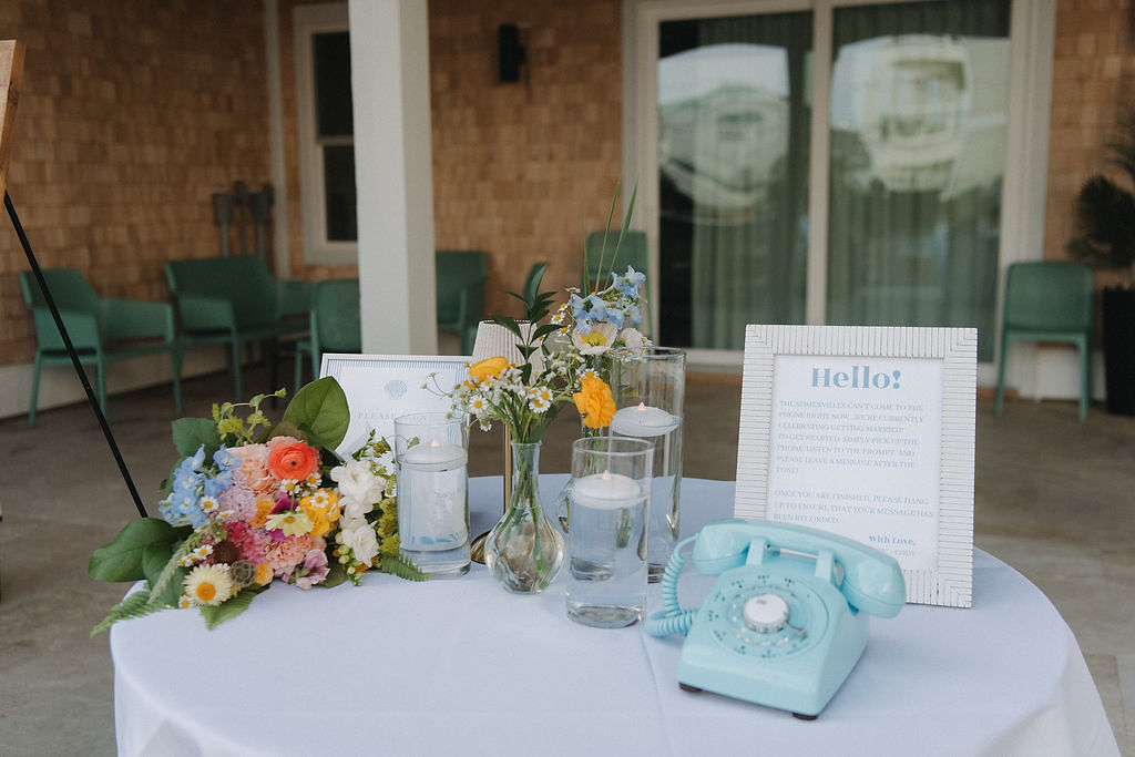 Audio guestbook table with blue retro phone and sign explaining how to use it