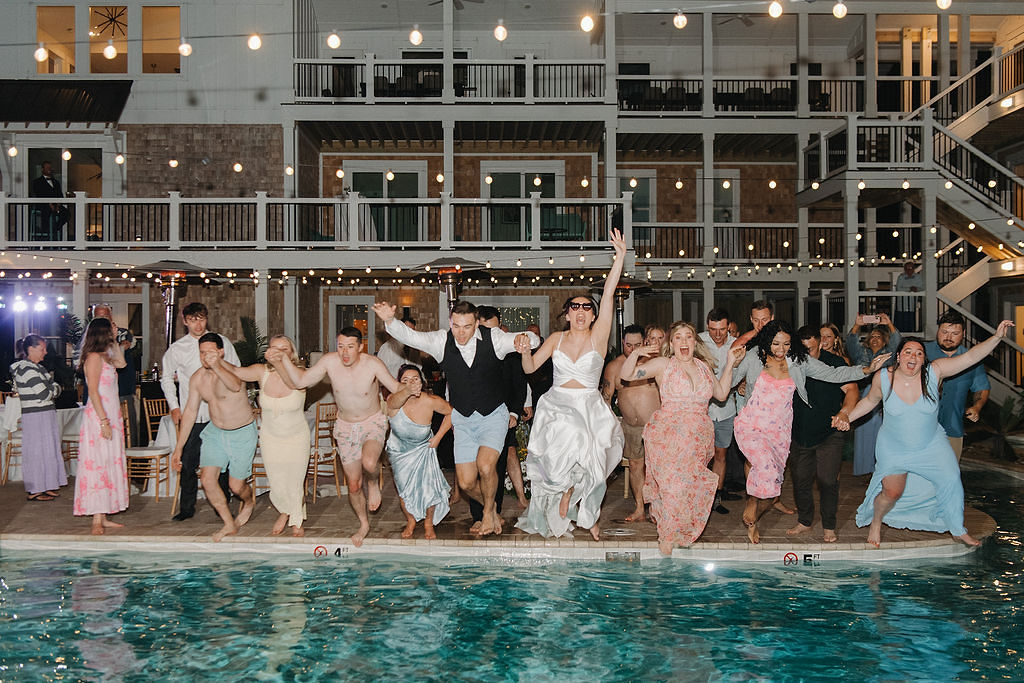 Bride and groom jumping into the beach house pool after their wedding reception in Outer Banks