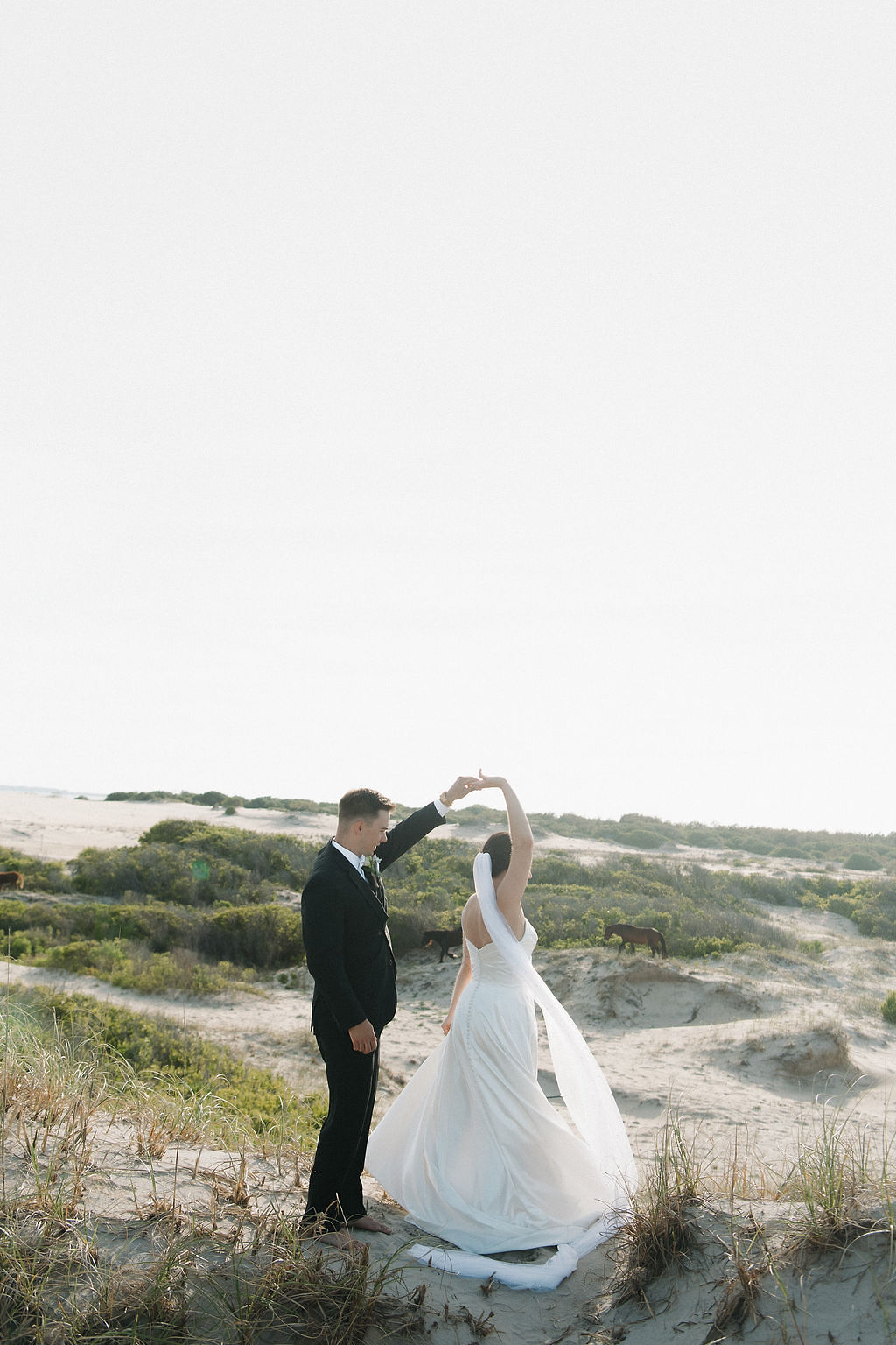 A newly married bride and groom in Corolla Outer Banks with wild horses