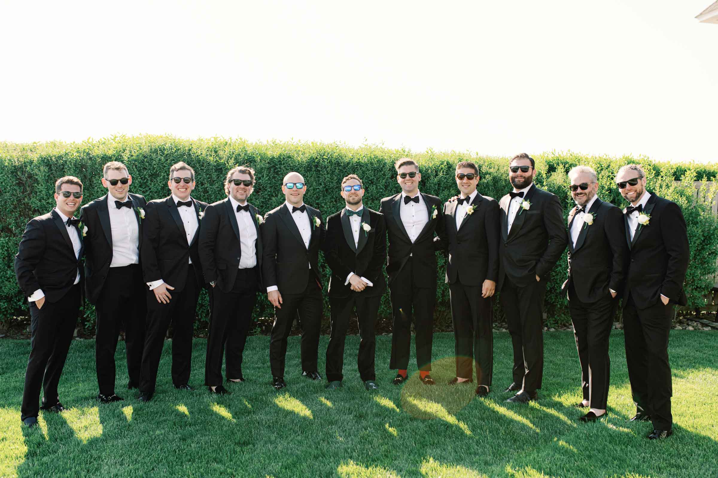 Groom and groomsmen wearing classic tuxedos for oceanside wedding