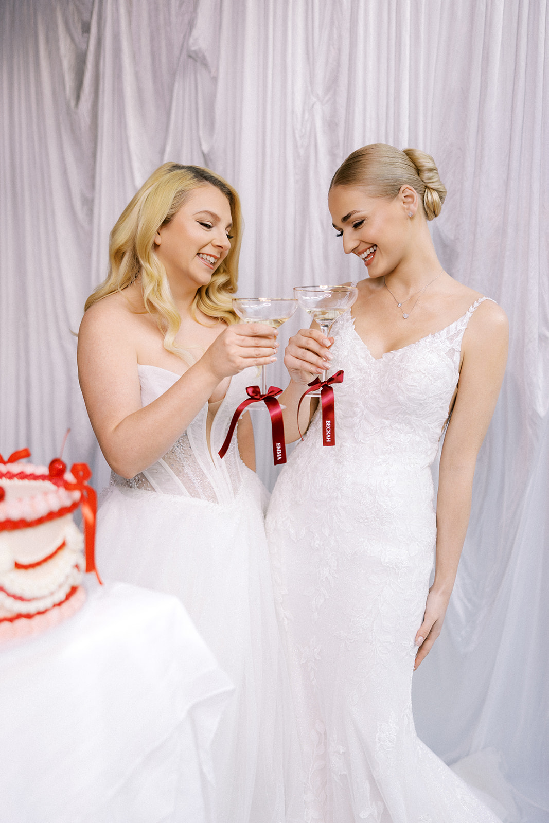 Two brides sharing a toast with their personalized DIY champagne glass ribbons