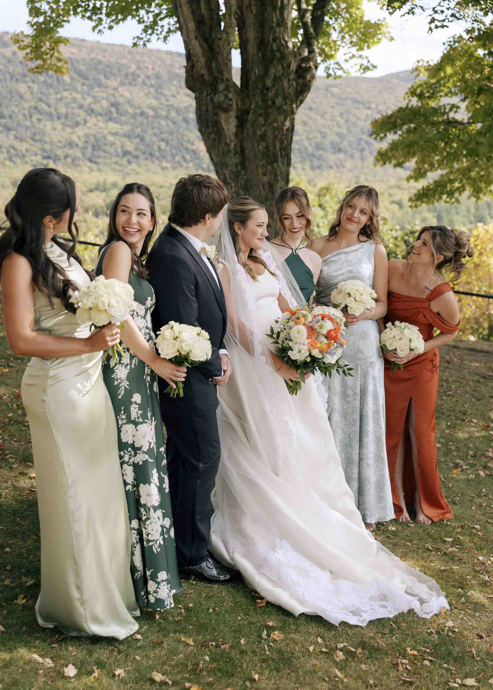 Bride with her wedding party wearing different dresses and suit