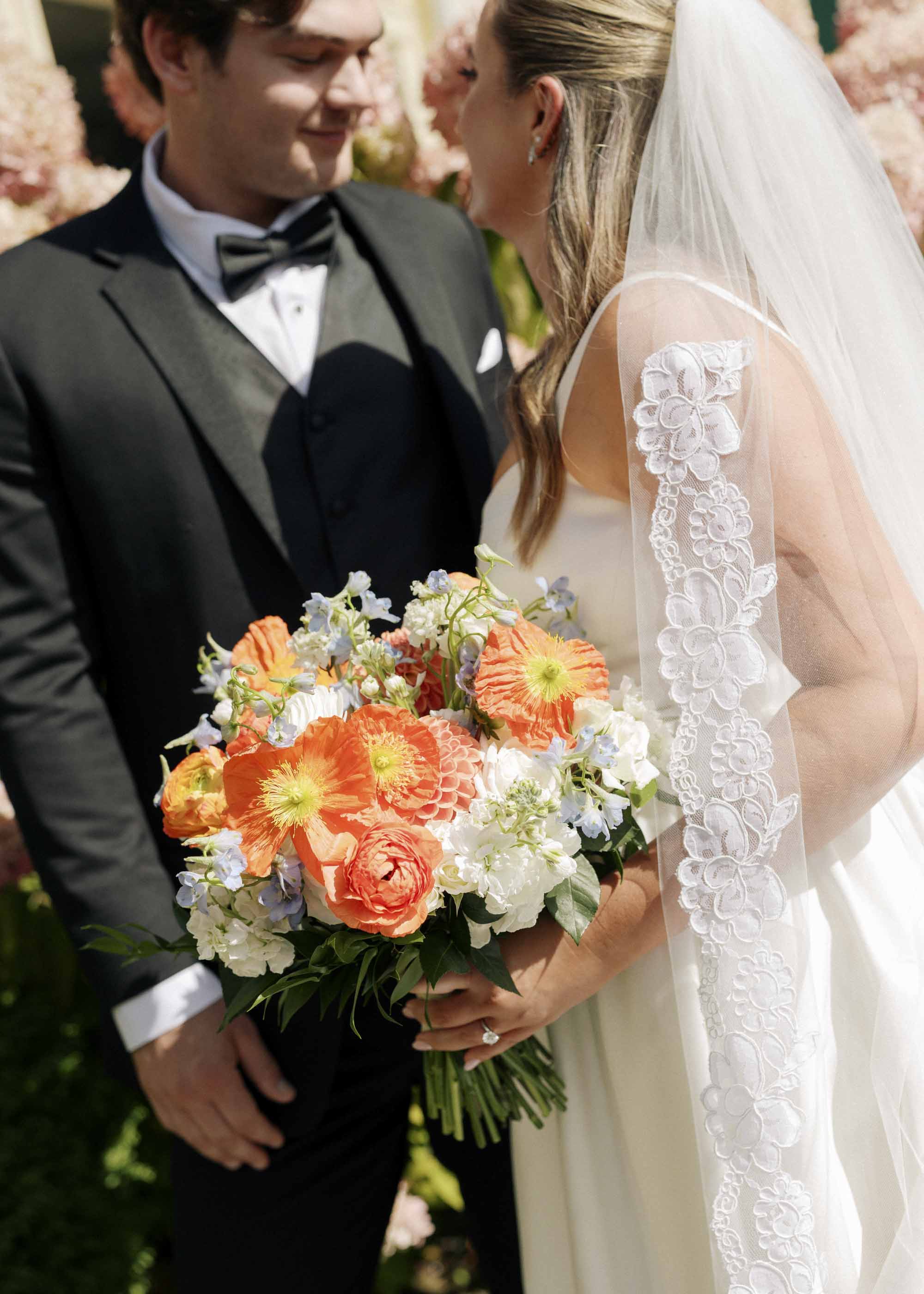 Orange wedding bouquet with big poppies and ranunculus and dahlias