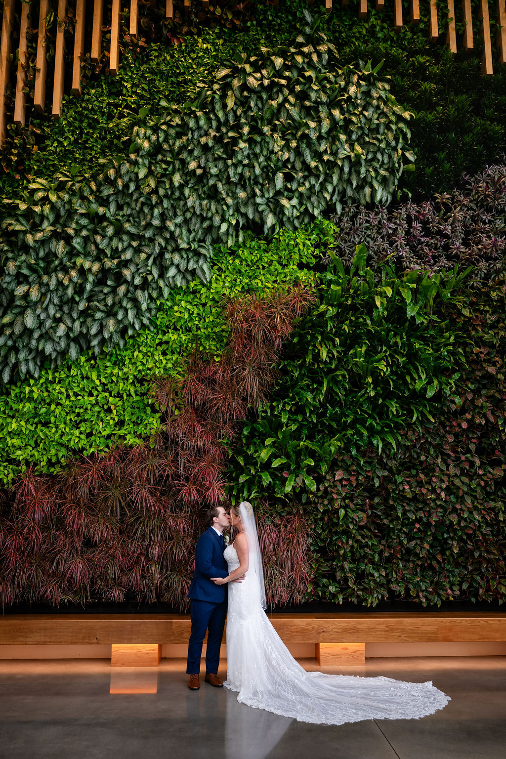Bride and groom in dramatic portrait in front of a living wall at the Marriott Virginia Beach Oceanfront
