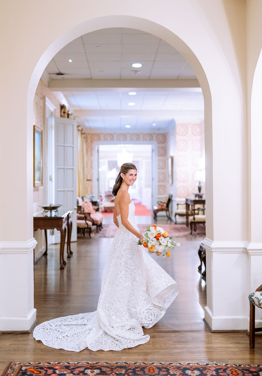 Bride wearing a laser cut satin applique strapless wedding dress with a classic pearl necklace