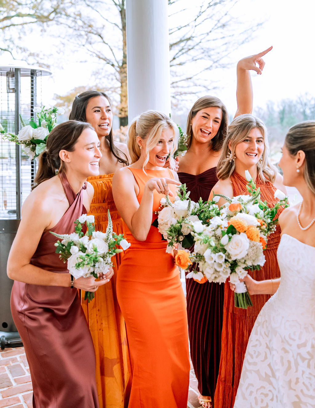 Colorful fall themed bridesmaid dresses in burgundy, orange, and rust
