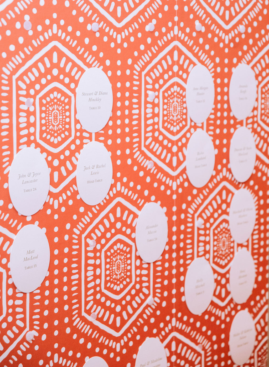 Bold orange patterned seating chart with oval escort cards