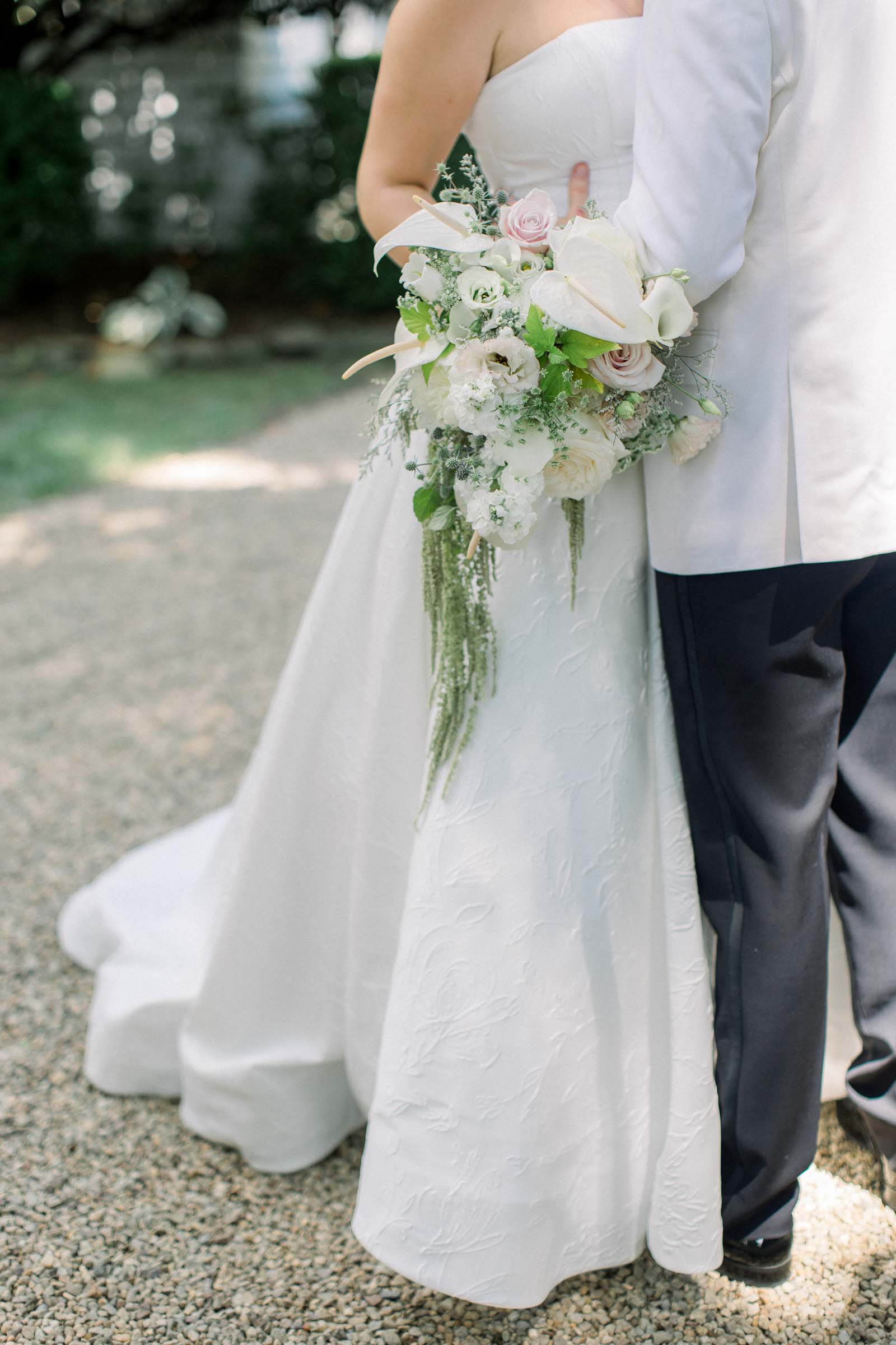 Cascading bridal bouquet with white anthurium, calla lilies, and amaranthus